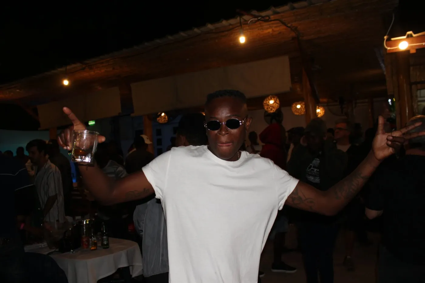 Guest celebrating with a drink under the lights